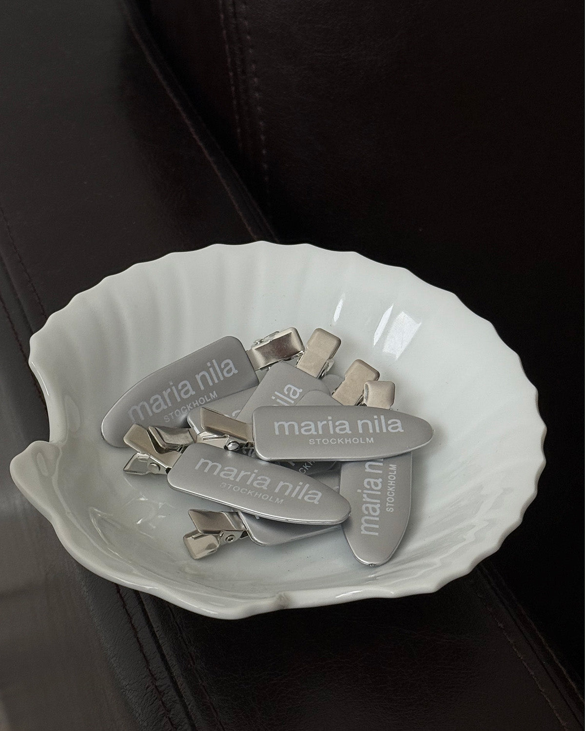 Silver hair clips in white bowl