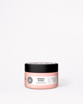 A pink jar of Mirror Gloss hair mask with a black lid, set against a plain white background.