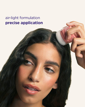 A close-up of a woman applying Refreshing Powder from a small round container onto her hair part, with text reading 'air-light formulation precise application' on a light beige background.